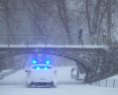 Police car cruises through the snow